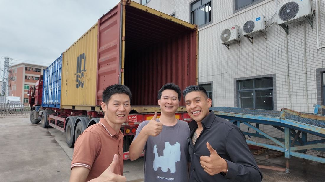Equipo de Kuaizi con el personal de la fábrica frente a un contenedor cargado