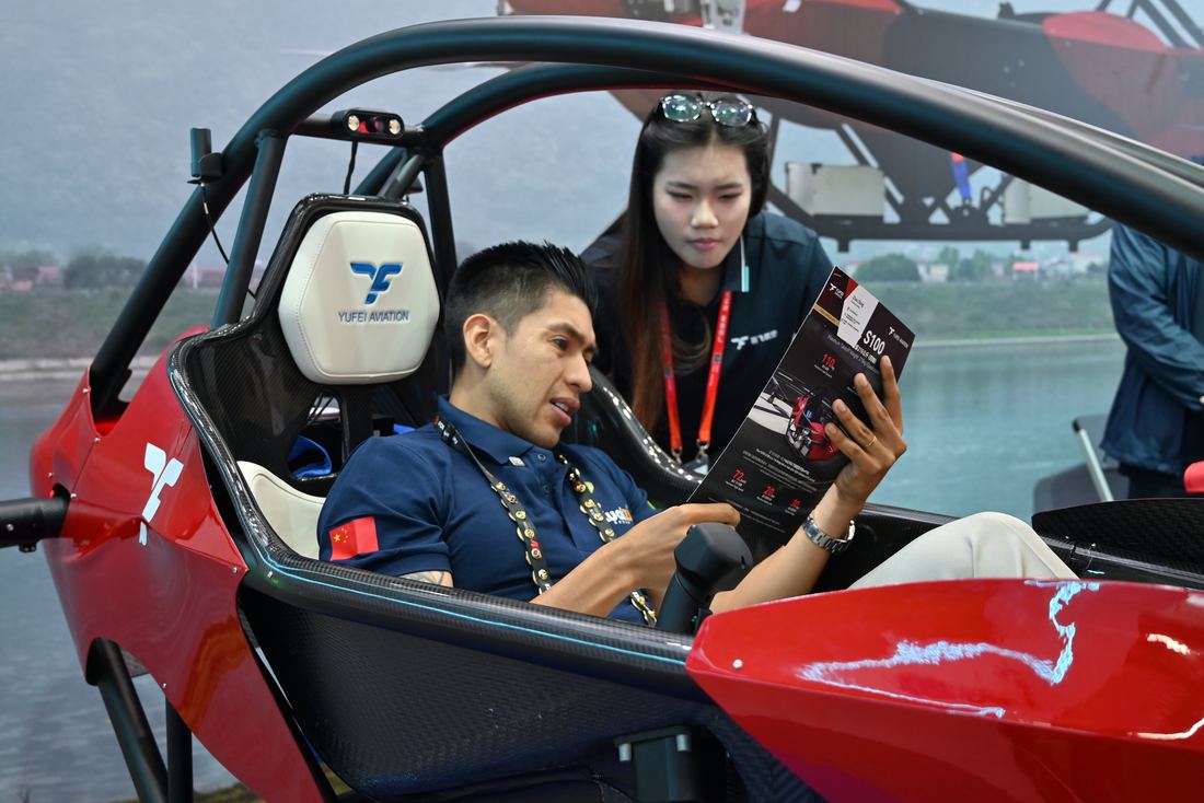 Felipe Hernández sentado en un vehículo eVTOL en un estand de la feria