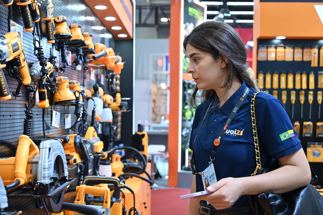 Asesora de Kuaizi revisando herramientas eléctricas en un estand