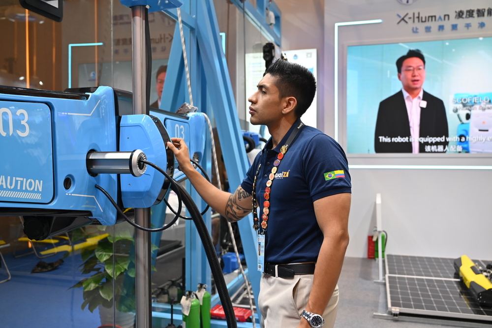Felipe Hernández revisando un robot industrial en la feria